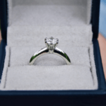 Hand holding engagement ring in a box